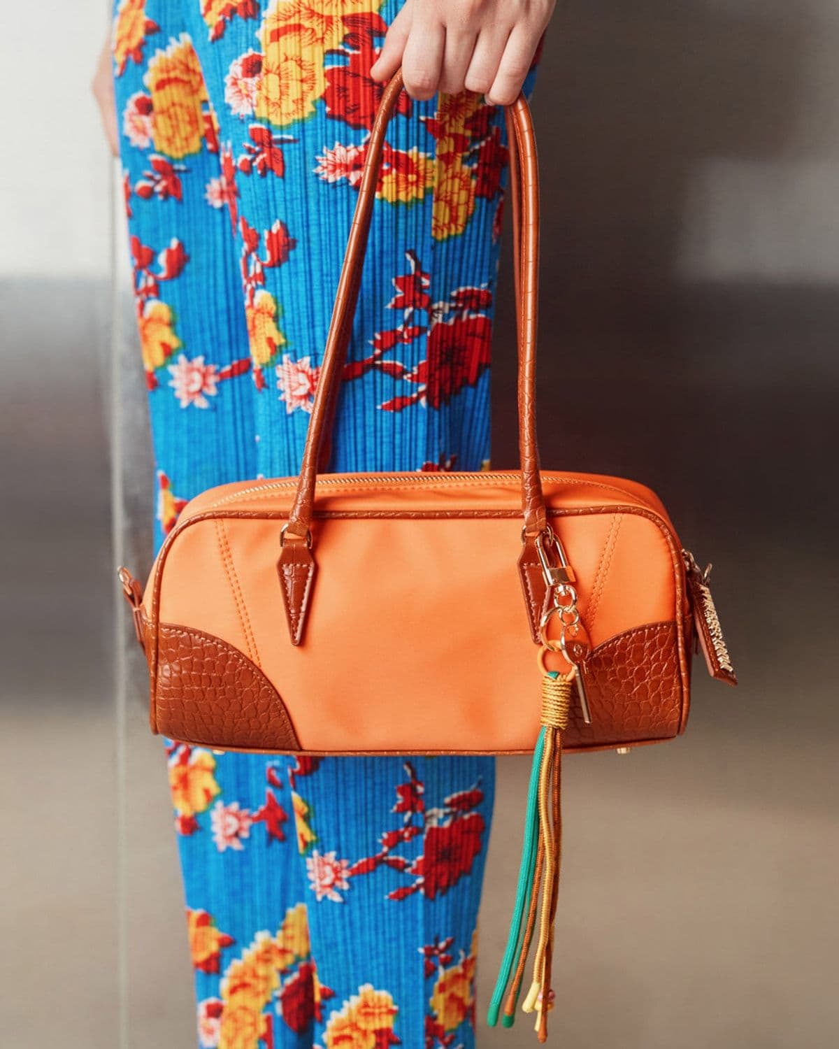 Brisk barrel bag in orange/tan, styled lifestyle photo on model